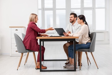 Photo of Real estate agent working with couple in new apartment