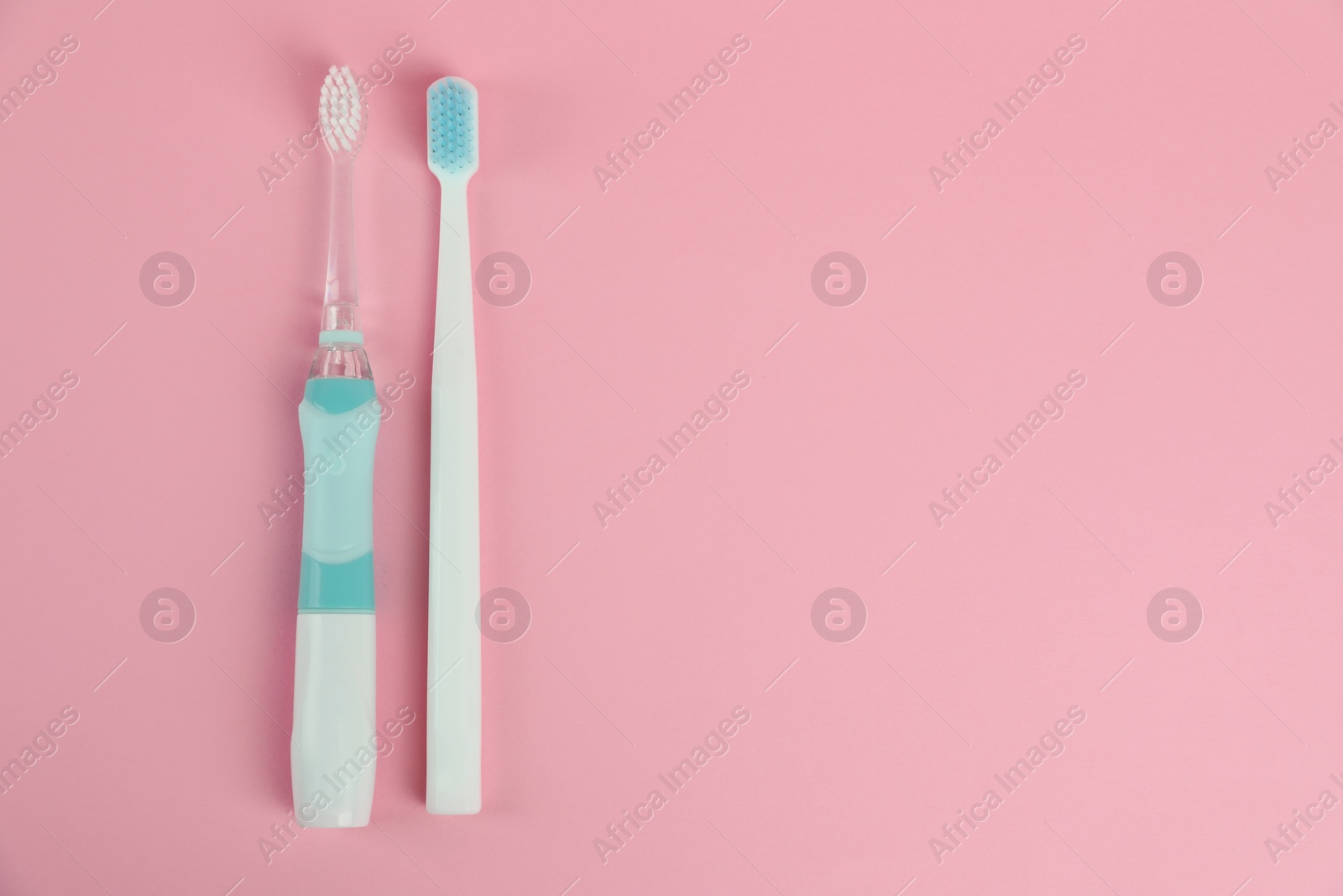 Photo of Electric and plastic toothbrushes on pink background, flat lay. Space for text