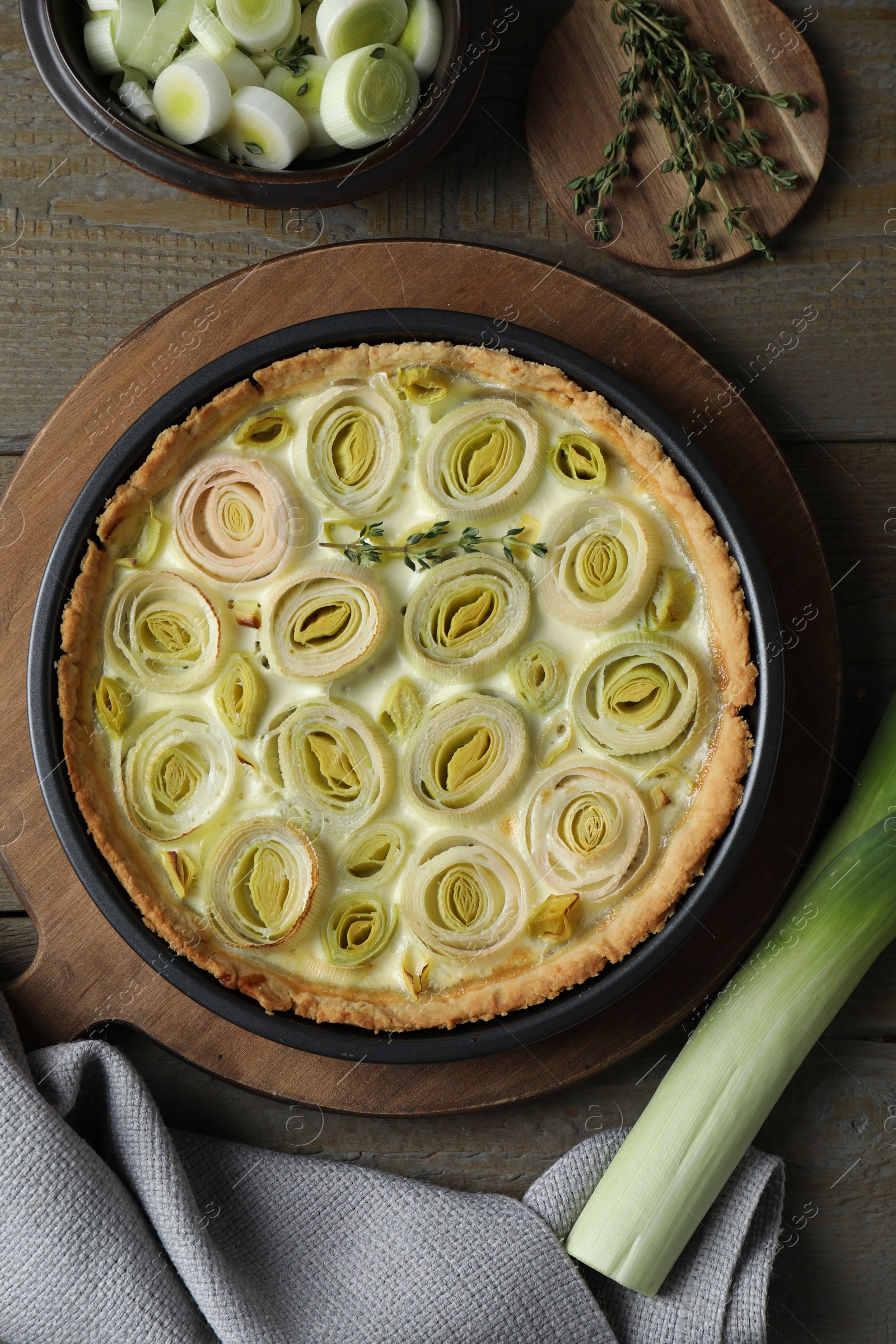 Photo of Tasty leek pie fresh stalk and thyme on wooden table