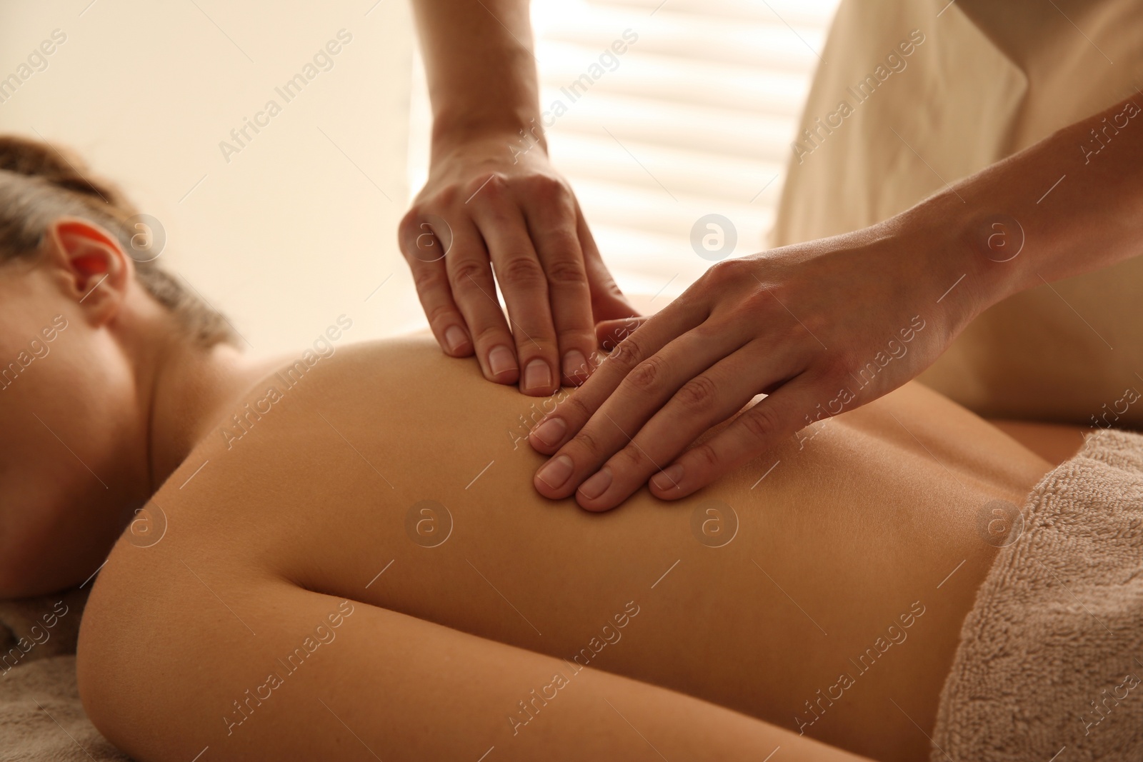 Photo of Young woman receiving back massage in spa salon, closeup