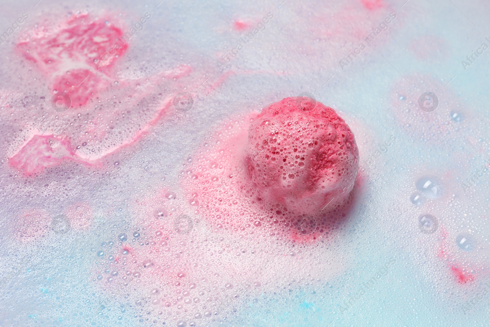 Photo of Beautiful pink bath bomb dissolving in water