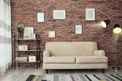 Photo of Modern living room interior with comfortable sofa near brick wall