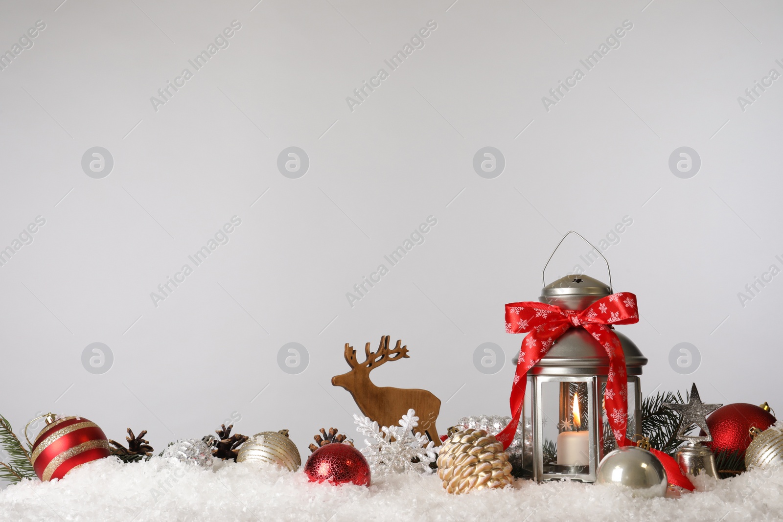 Photo of Beautiful composition with vintage Christmas lantern and festive decorations on snow against white background. Space for text