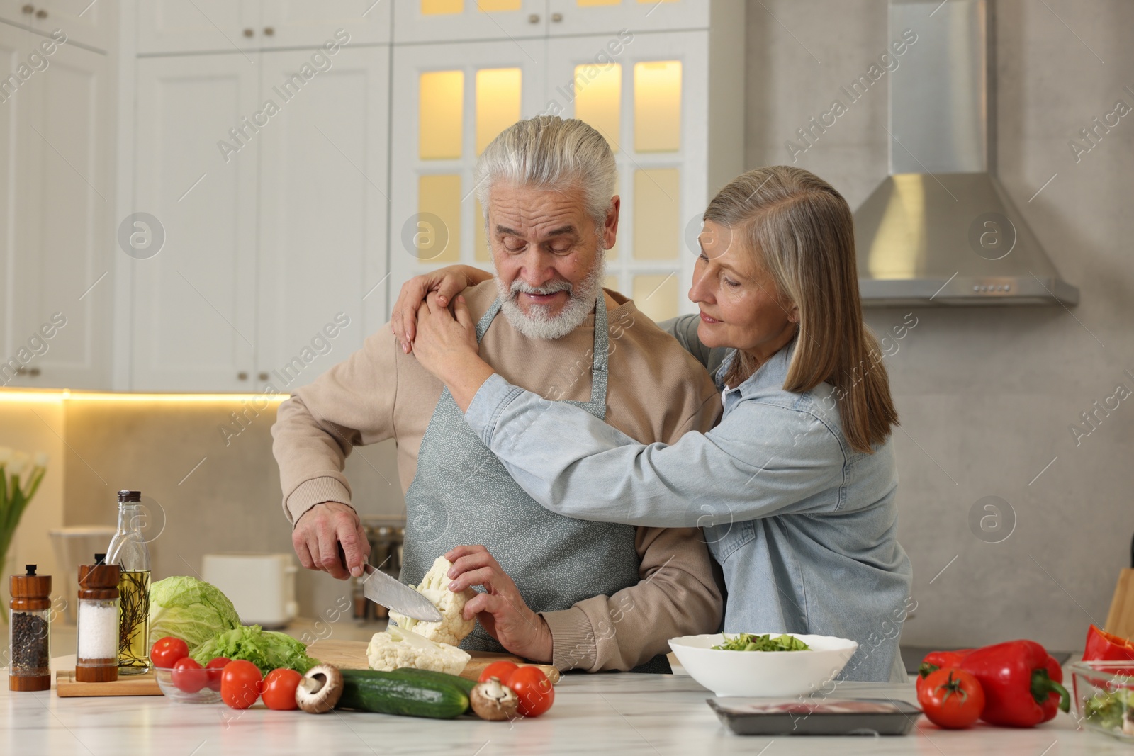 Photo of Happy senior couple cooking together in kitchen