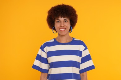 Portrait of happy young woman on orange background