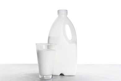 Gallon bottle of milk and glass on light grey table
