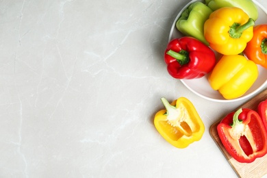 Photo of Whole and cut bell peppers on marble table, top view. Space for text