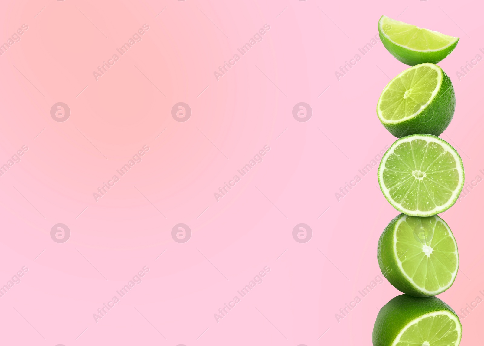 Image of Stacked cut limes on light pink background, space for text