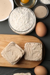 Different types of yeast, eggs and flour on grey wooden table, flat lay