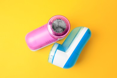 Modern fabric shavers on yellow background, flat lay