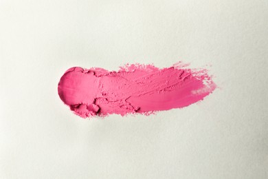 Photo of Smear of beautiful lipstick on beige background, top view