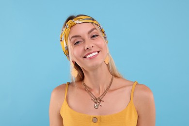 Photo of Portrait of happy hippie woman on light blue background