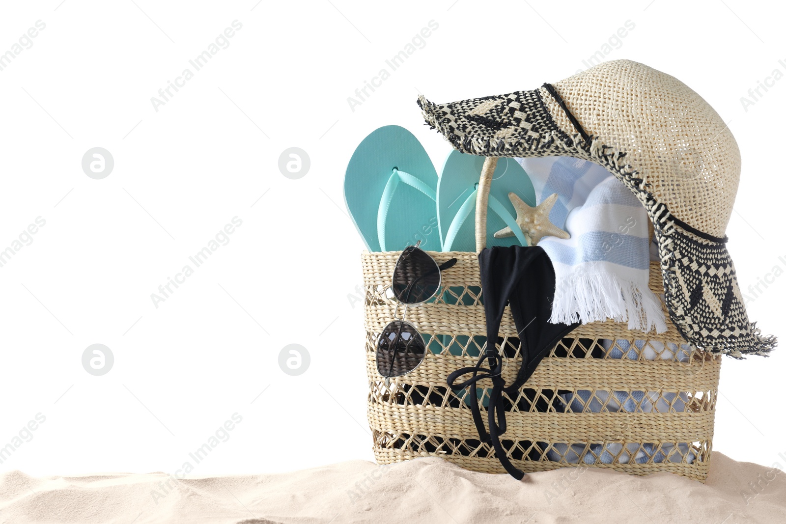 Photo of Bag with beach objects on sand against white background, space for text
