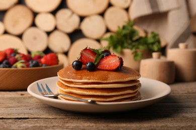 Photo of Tasty pancakes with fresh berries and mint on wooden table