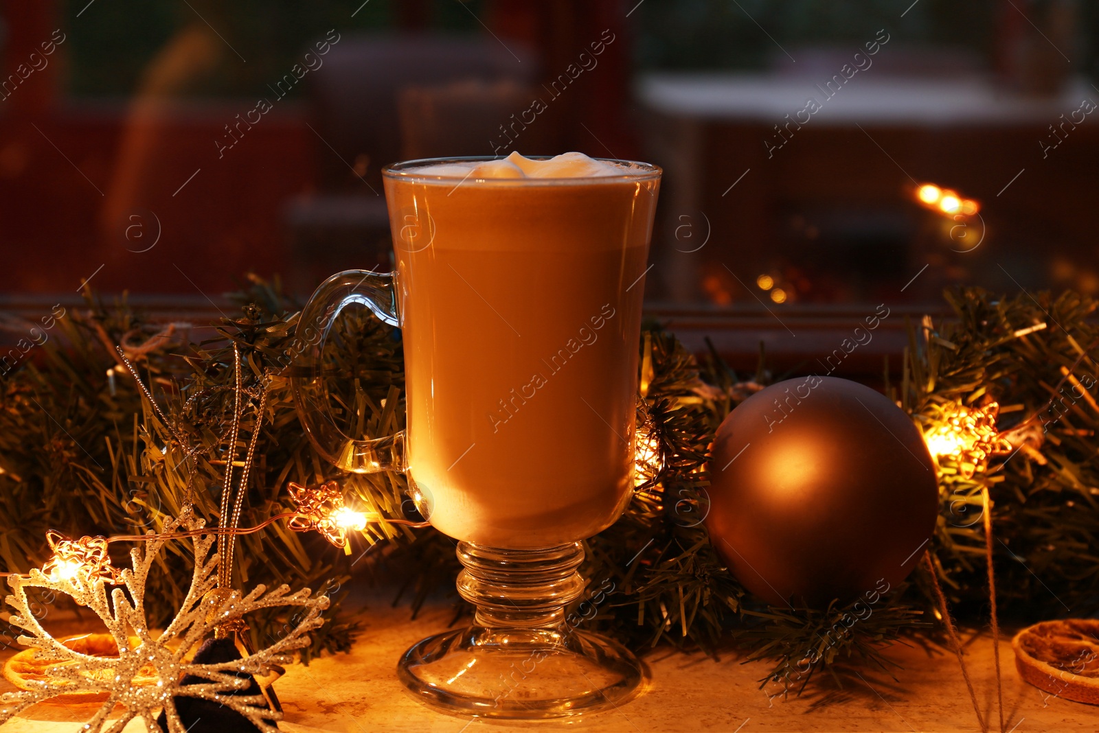 Photo of Glass of delicious hot cocoa and Christmas decoration on windowsill