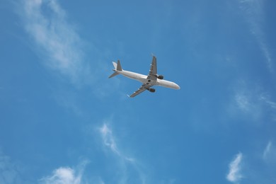 Photo of Modern airplane flying in blue sky low angle view