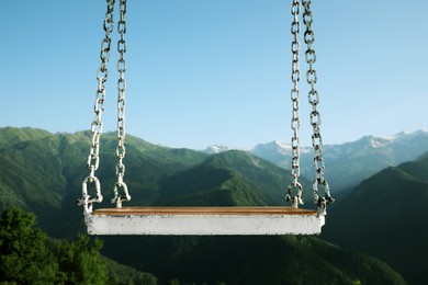 Photo of Outdoor metal swing in beautiful mountains on sunny day