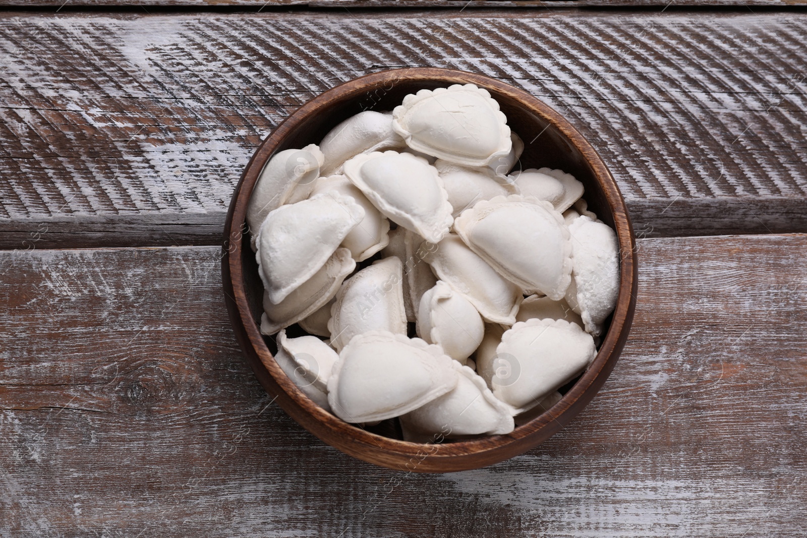 Photo of Raw dumplings (varenyky) on wooden table, top view