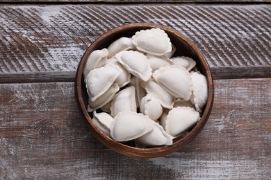 Photo of Raw dumplings (varenyky) on wooden table, top view