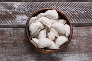 Raw dumplings (varenyky) on wooden table, top view