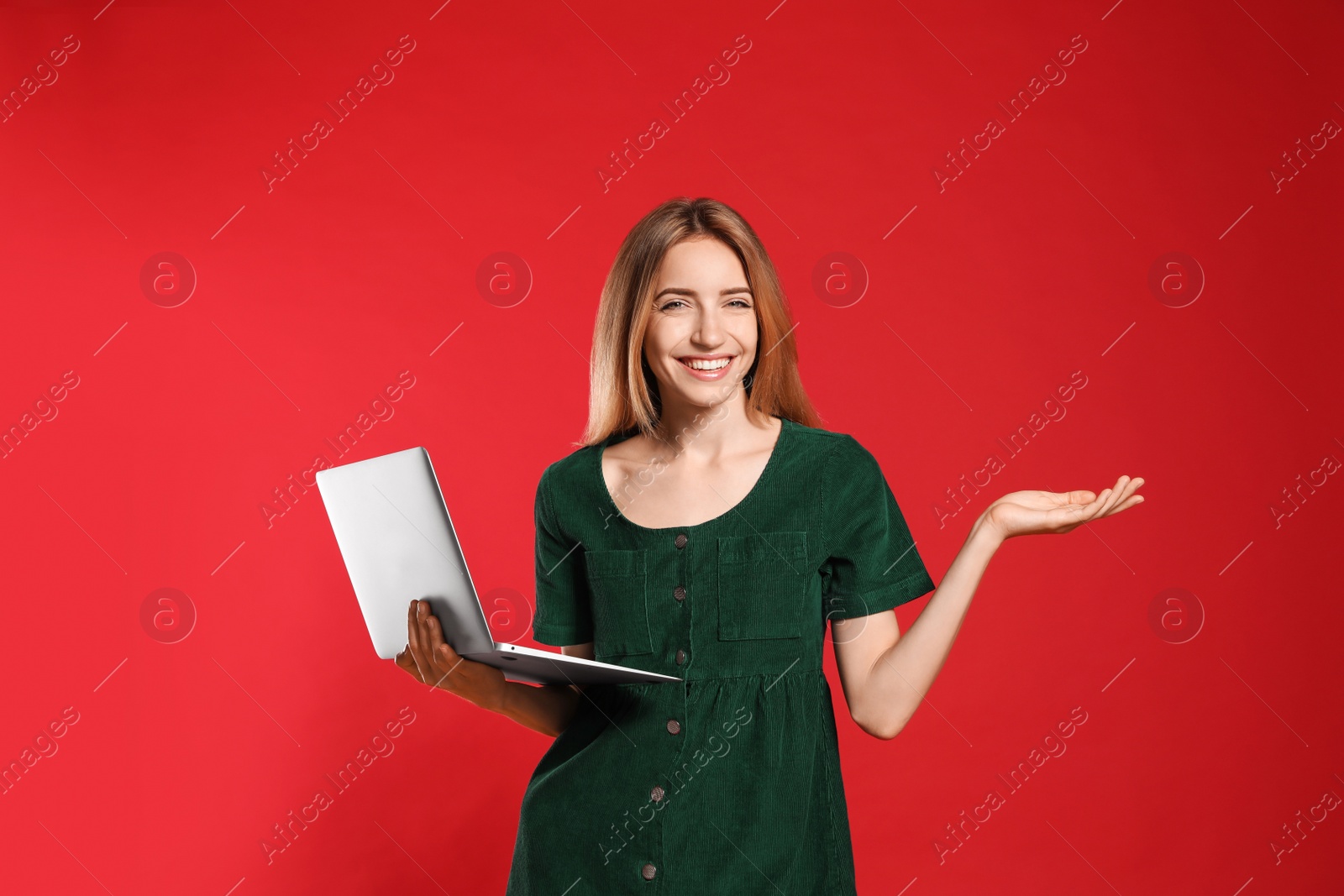 Photo of Portrait of young woman with modern laptop on red background