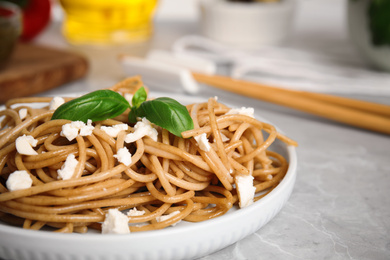 Photo of Tasty buckwheat noodles served on light grey table, closeup