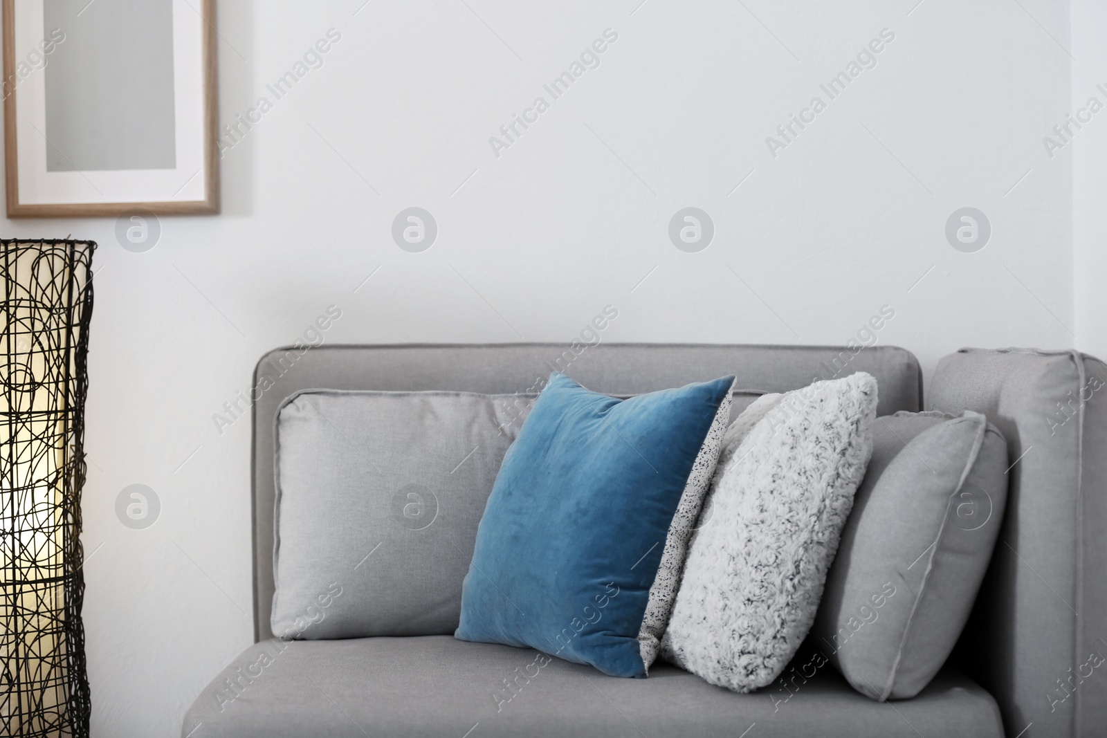 Photo of Different soft pillows on sofa in room. Interior element