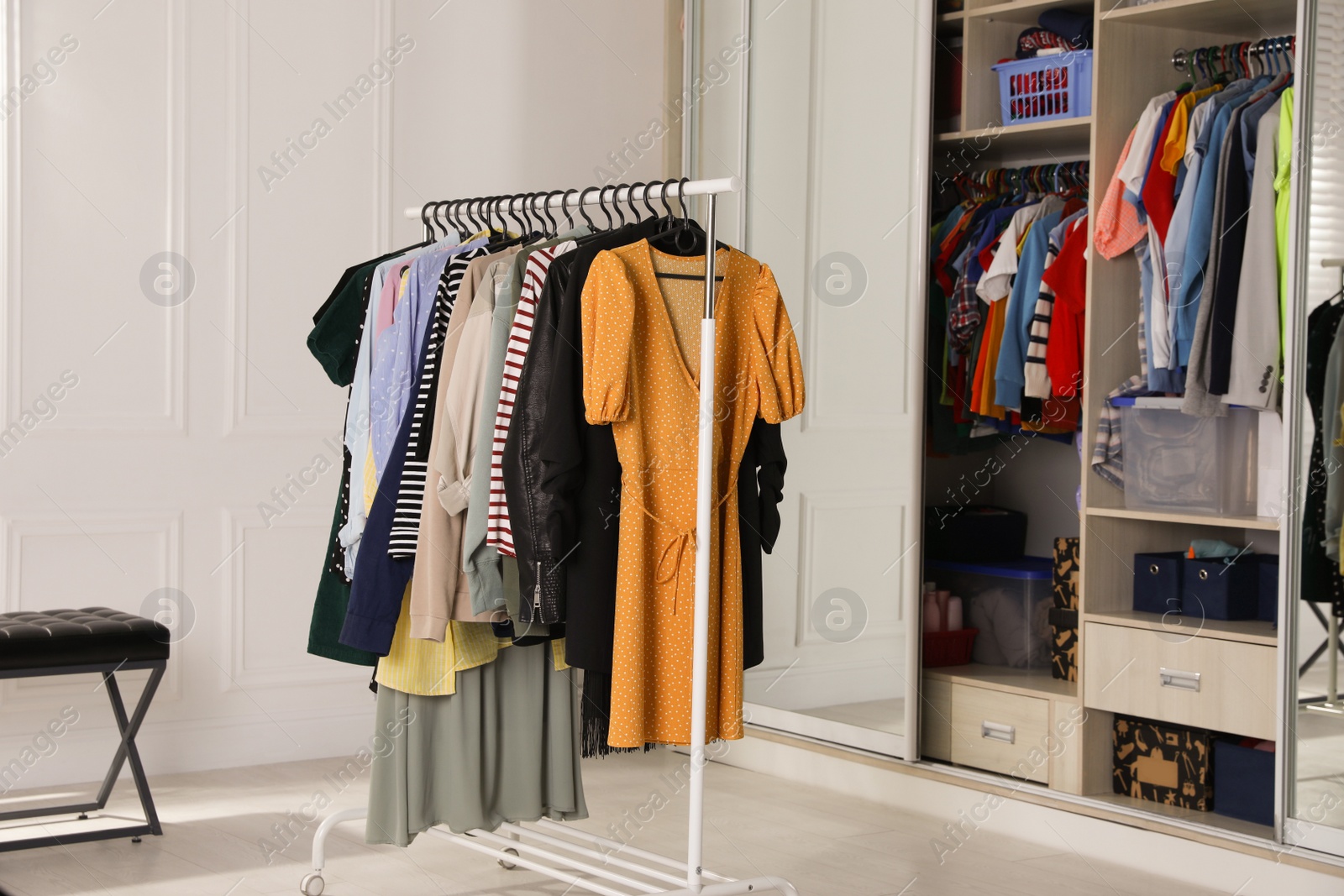 Photo of Rack with stylish women's clothes in dressing room