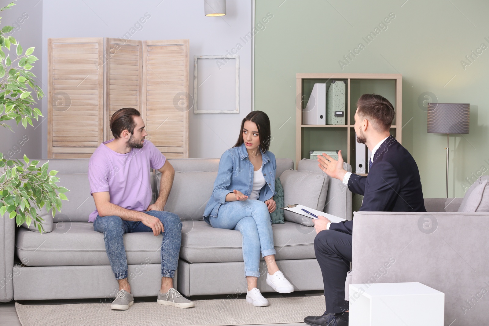 Photo of Family psychologist working with young couple in office