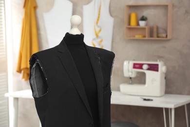 Photo of Mannequin with unfinished suit jacket in tailor shop