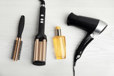Photo of Flat lay composition with hairdressing equipment on white wooden background