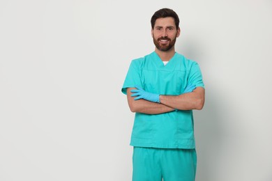 Photo of Happy nurse in medical uniform on white background, space for text