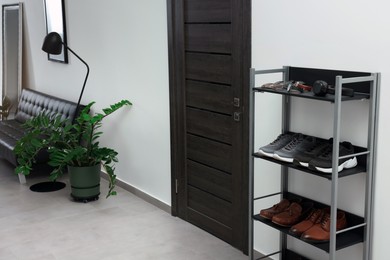 Photo of Shoe storage unit near wooden door in hallway. Interior design