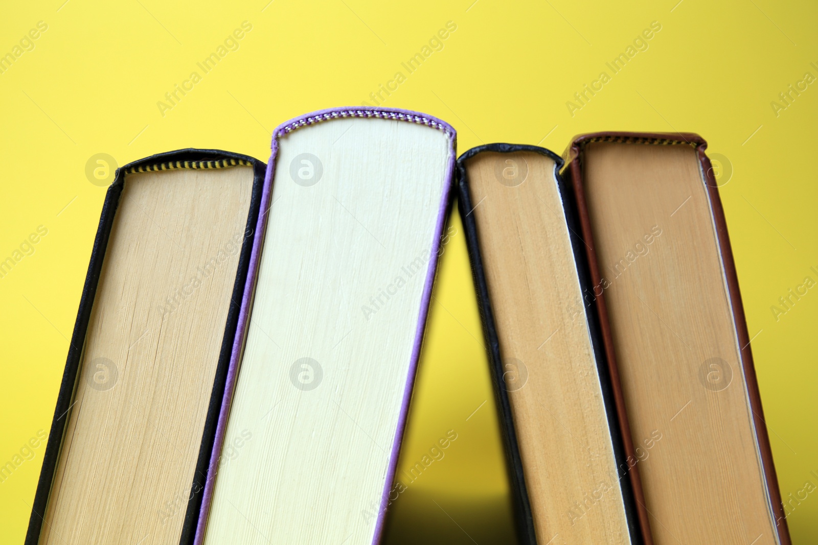 Photo of Collection of hardcover books on yellow background