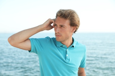 Portrait of handsome young man near sea