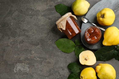 Delicious quince jam and fruits on grey table, flat lay. Space for text