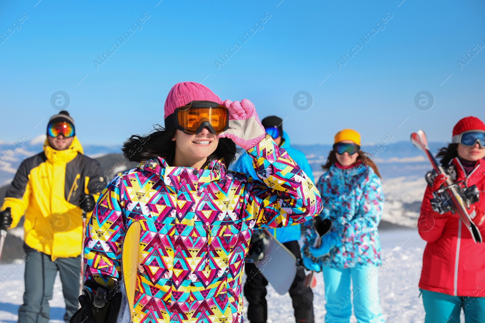 Photo of Young woman with snowboard at ski resort. Winter vacation