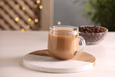 Photo of Delicious coffee with milk in cup on white wooden table