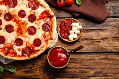 Flat lay composition with hot pepperoni pizza on wooden table