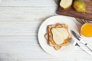 Photo of Slice of bread with peanut butter and pear on white wooden table, flat lay. Space for text
