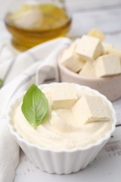 Delicious tofu sauce and basil leaf on white wooden table, closeup