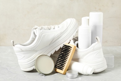 Photo of Composition with stylish footwear and shoe care accessories on light grey table