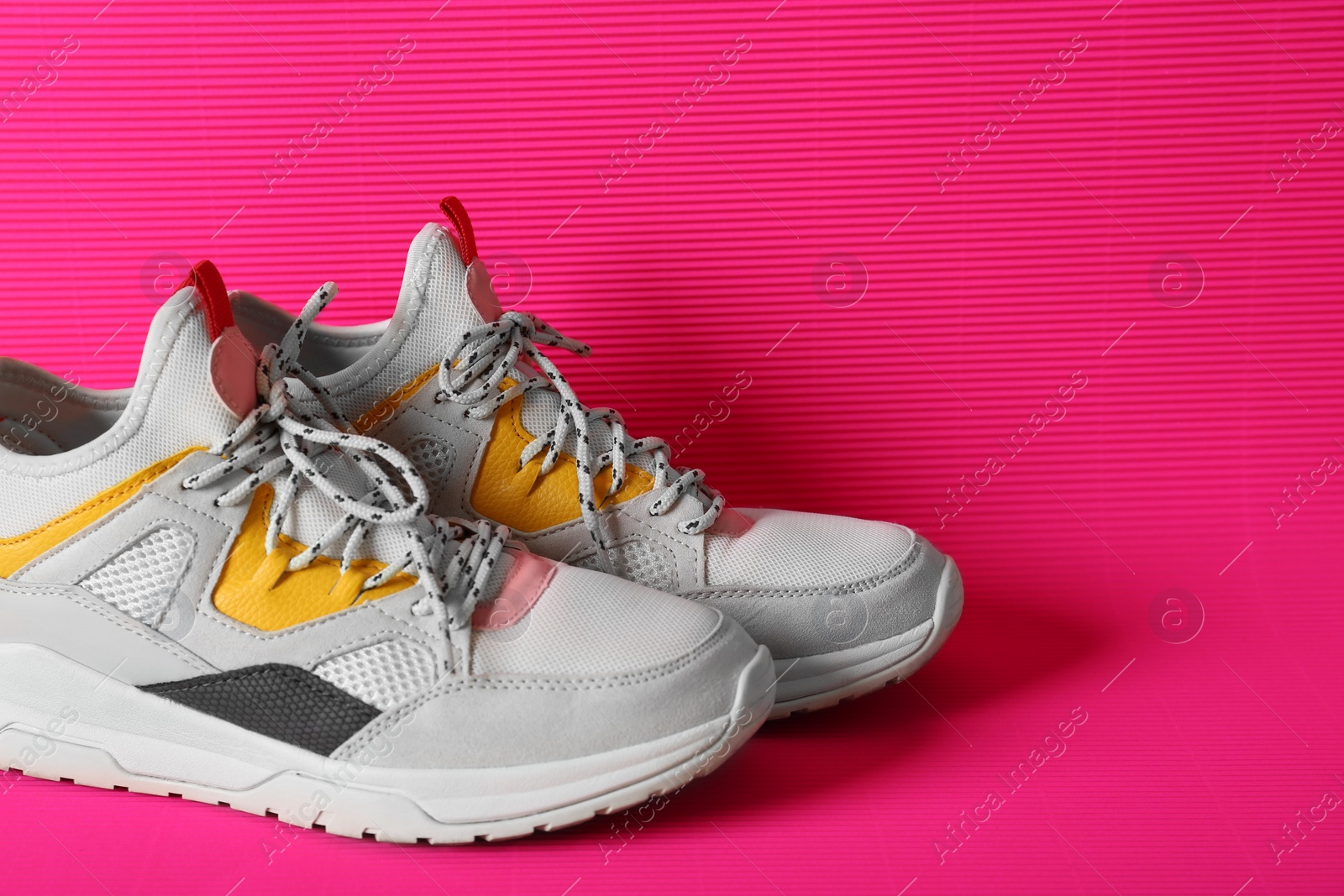 Photo of Pair of sneakers on color background. Space for text