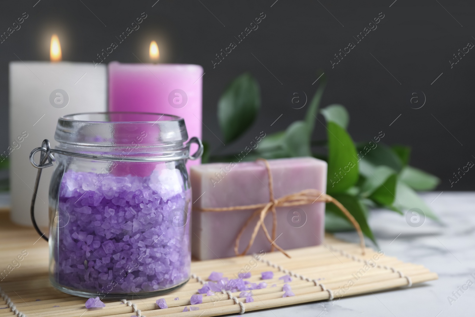 Photo of Composition with aromatic salt, handmade soap and bamboo mat on table. Space for text