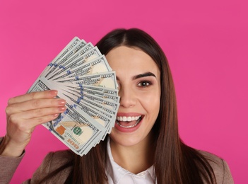 Young businesswoman with money on color background