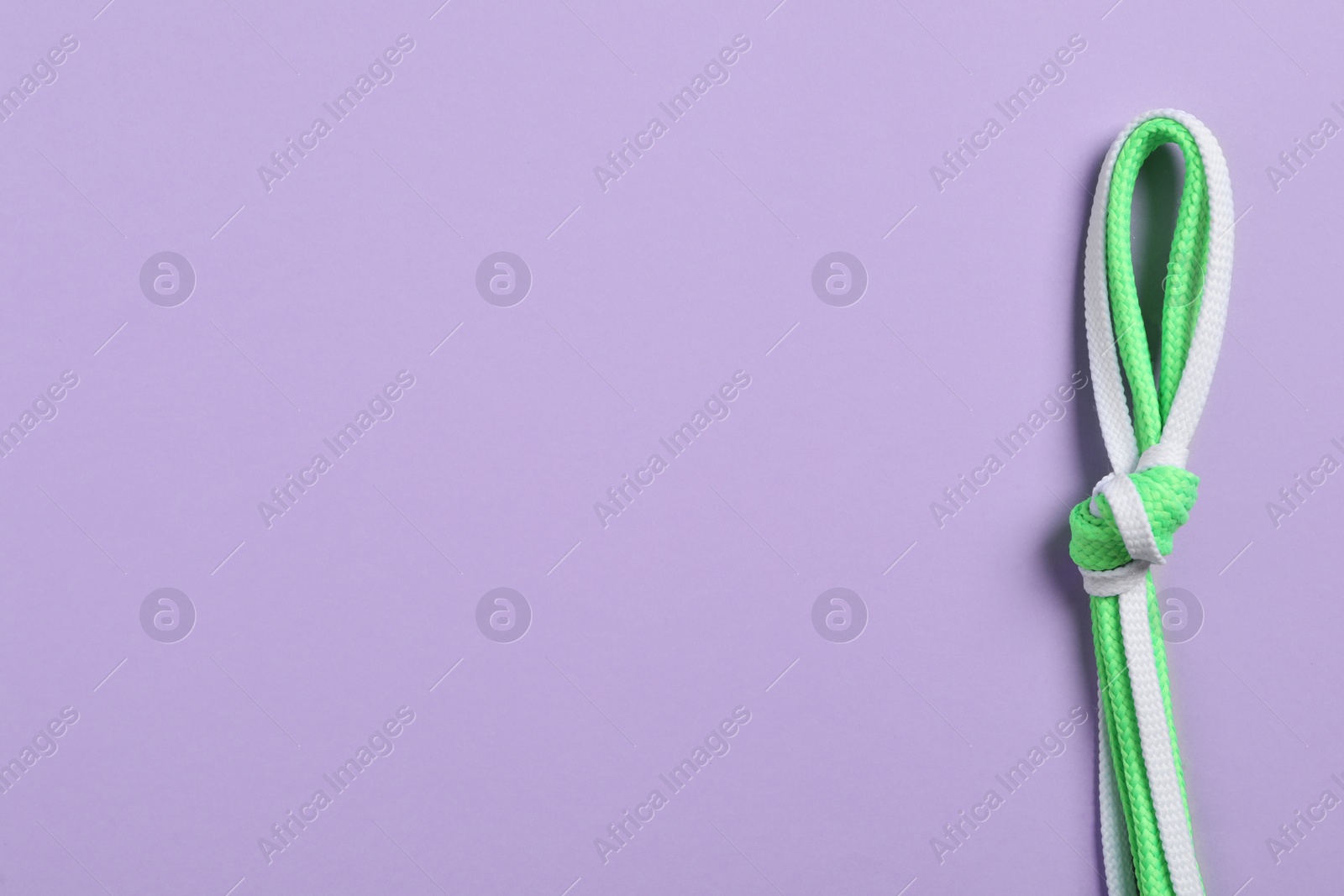 Photo of Different shoelaces on lilac background, top view. Space for text