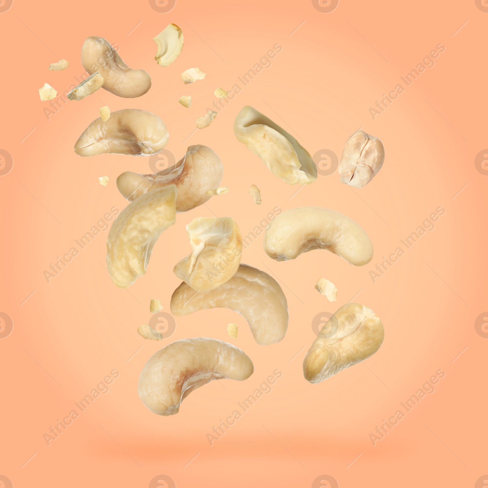 Image of Tasty cashew nuts flying on pink background