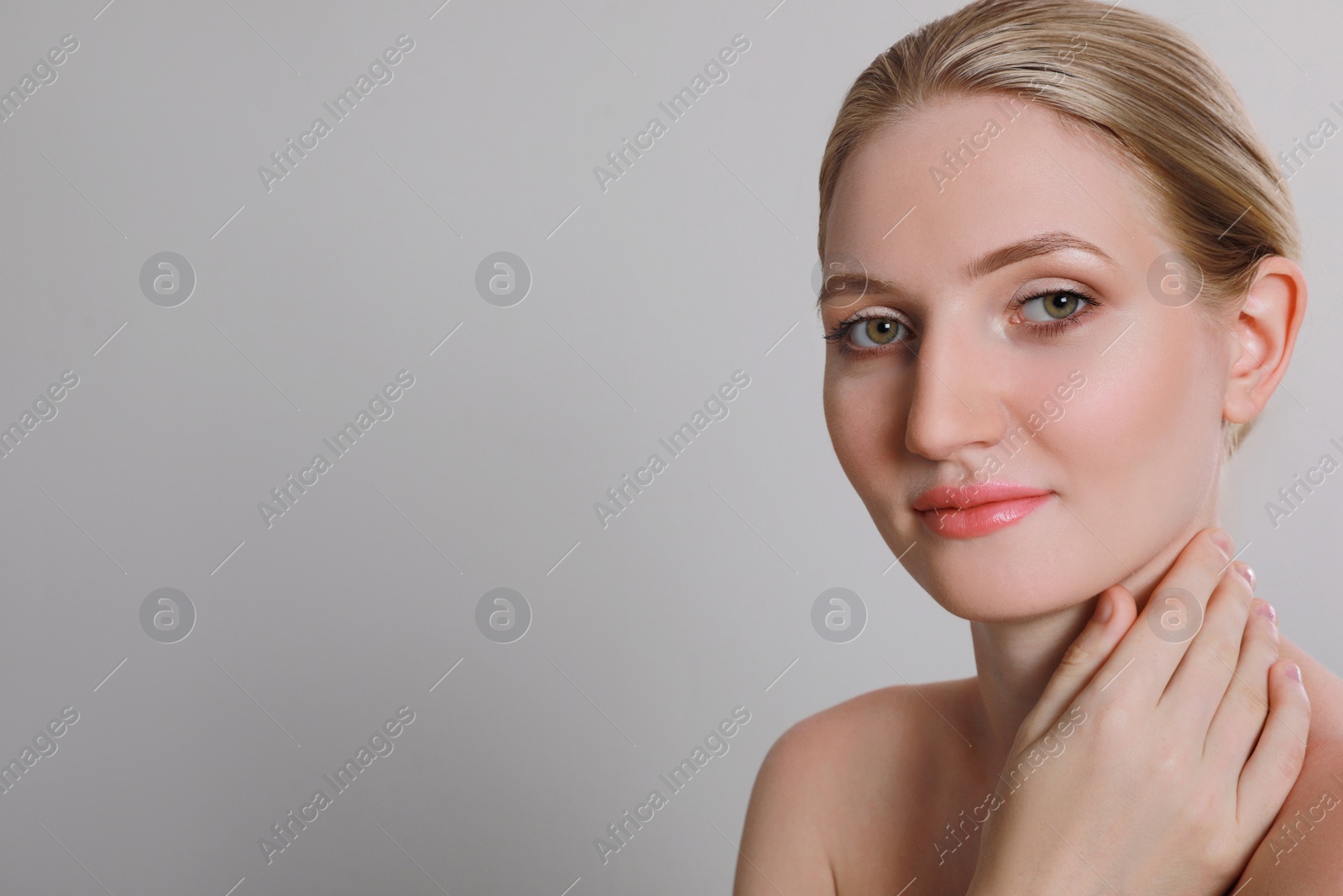 Photo of Portrait of young woman with beautiful face on light grey background. Space for text