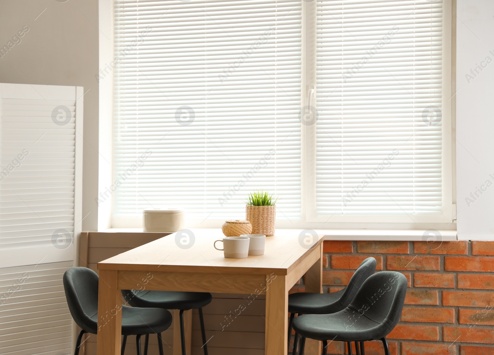 Photo of Stylish dining room interior with modern table set and window blinds