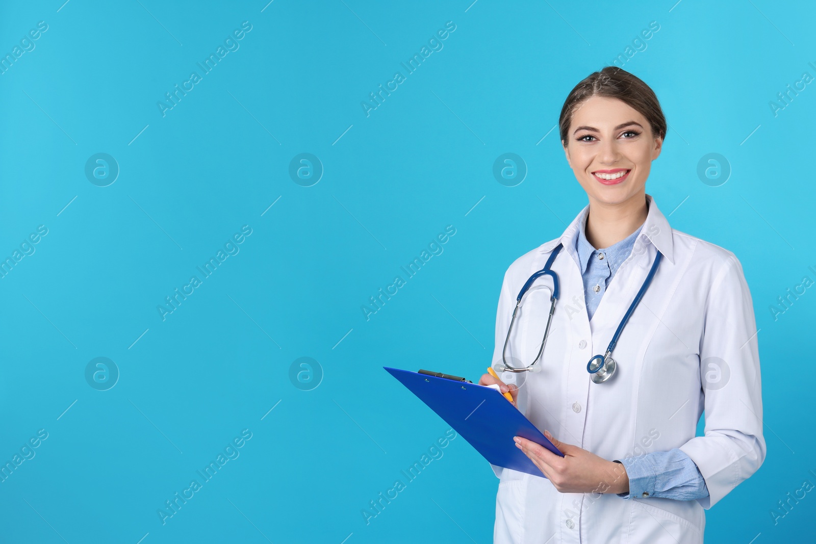 Photo of Young medical student with clipboard on color background. Space for text